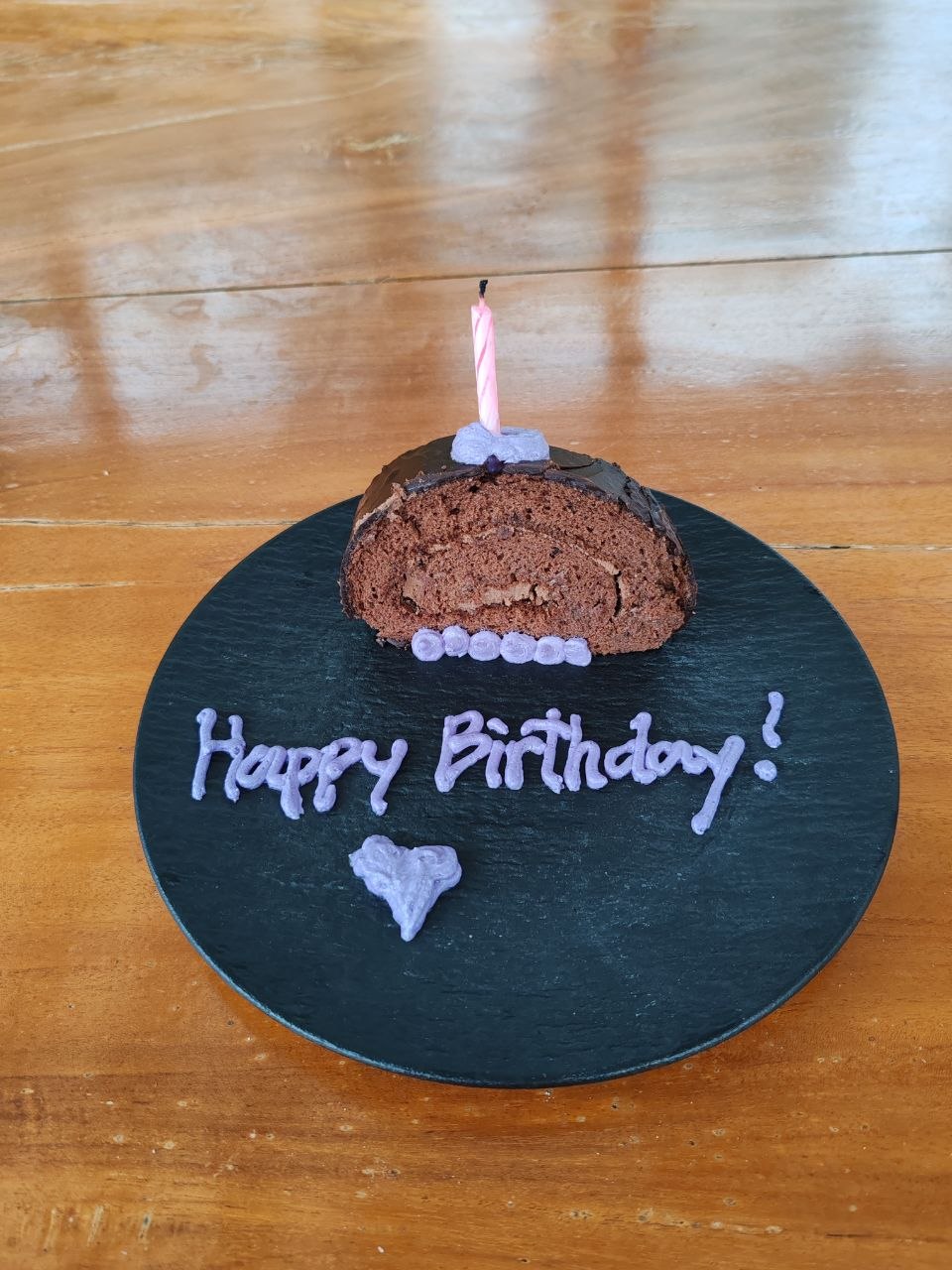 Birthday cake — кусочек шоколадного рулета со свечкой и Happy Birthday